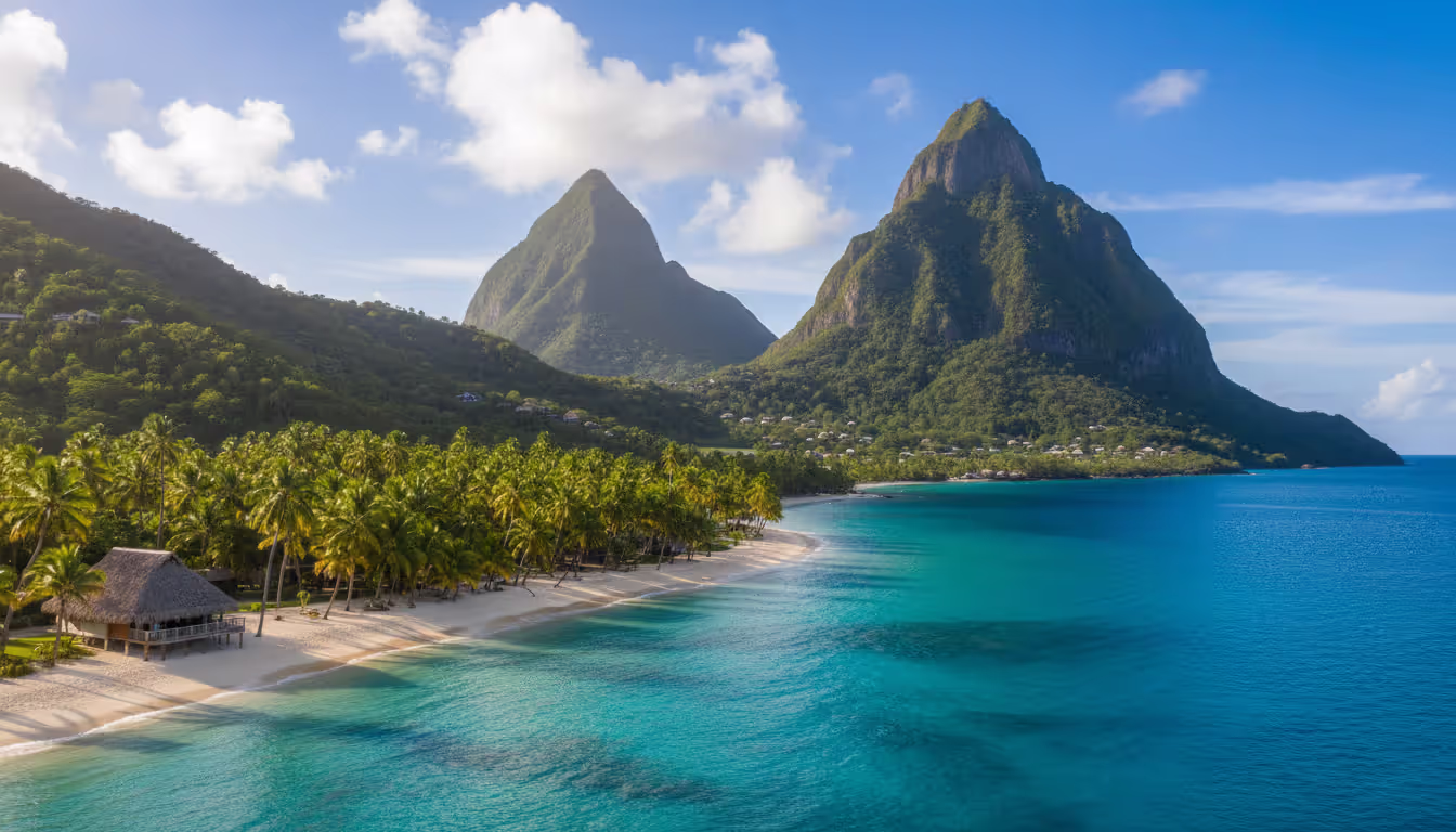 The Pitons volcanic peaks in Saint Lucia rising from turquoise Caribbean sea with resort beach